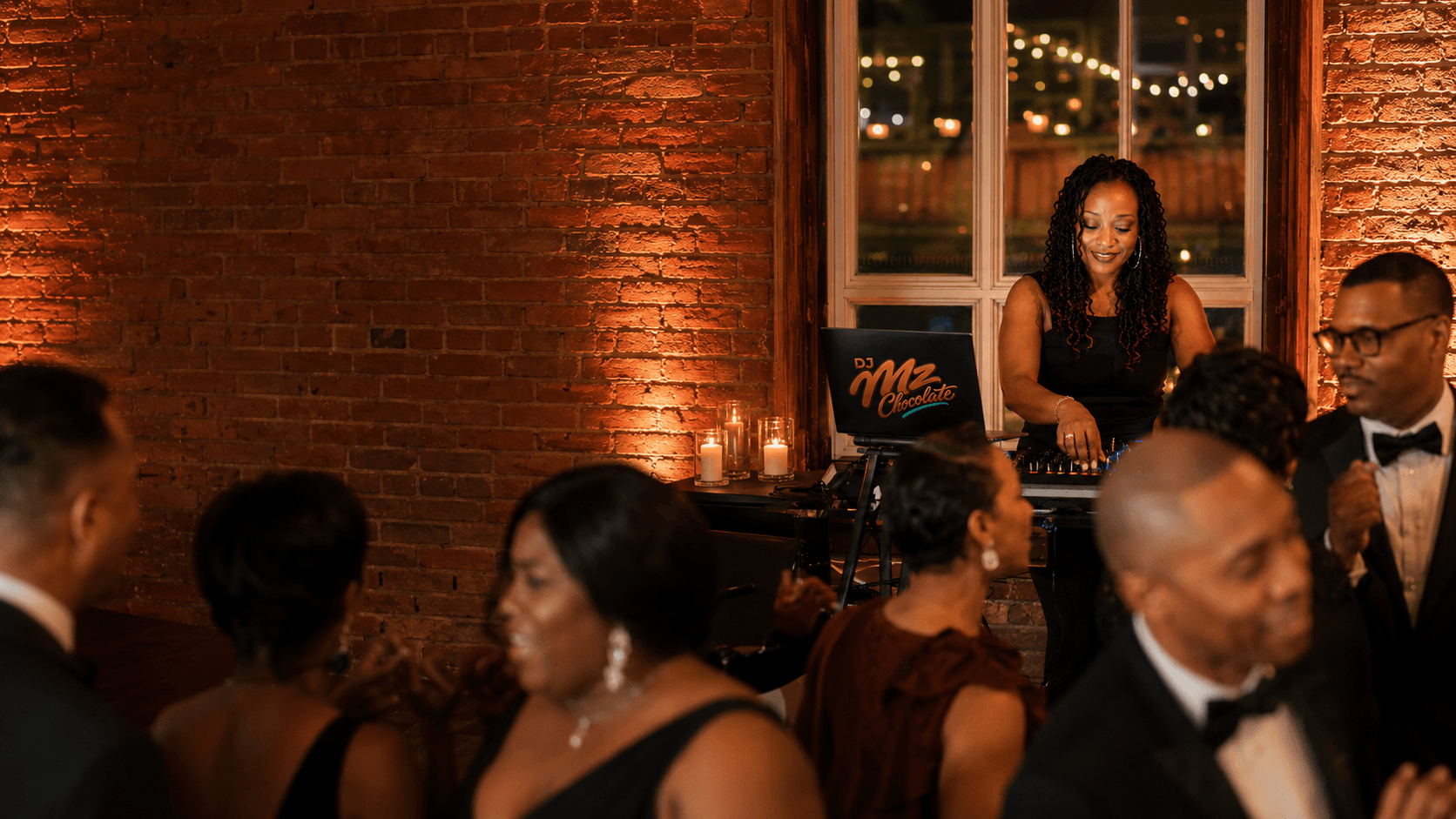 DJ Mz Chocolate behind the DJ booth at a warm event